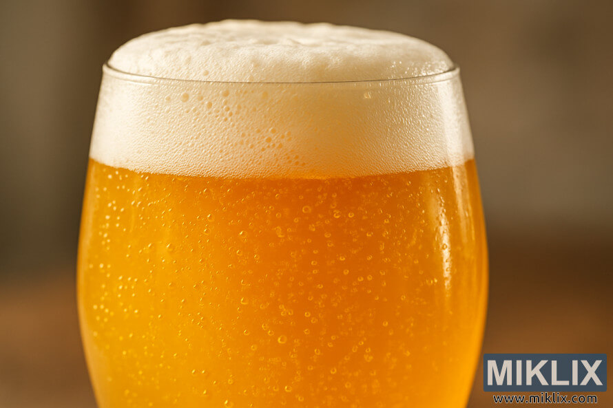DetailnÃ½ zÃ¡ber na pohÃ¡r zlatÃ©ho bavorskÃ©ho pÅ¡eniÄnÃ©ho piva s krÃ©movou penou a stÃºpajÃºcimi bublinkami.