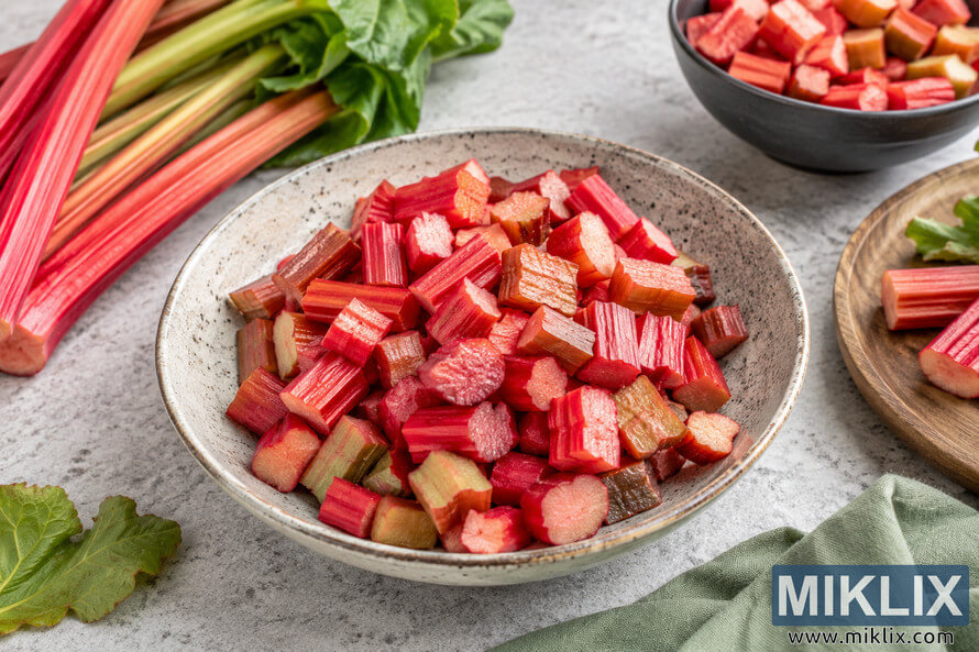 A high-resolution landscape food photograph featuring a ceramic bowl filled with freshly chopped rhubarb on a light stone countertop, surrounded by whole rhubarb stalks, leafy greens, a wooden cutting board, and soft natural lighting to emphasize healthy eating and weight management. A high-resolution landscape food photograph featuring a ceramic bowl filled with freshly chopped rhubarb on a light stone countertop, surrounded by whole rhubarb stalks, leafy greens, a wooden cutting board, and soft natural lighting to emphasize healthy eating and weight management.