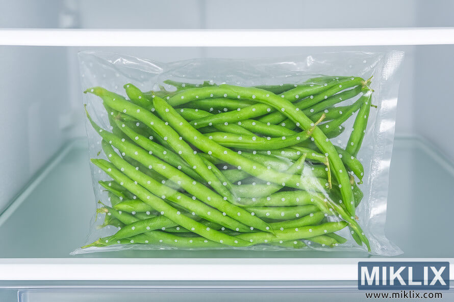 Tuoreita vihreitÃ¤ papuja sÃ¤ilytettynÃ¤ rei'itetyssÃ¤ muovipussissa jÃ¤Ã¤kaapin laatikossa