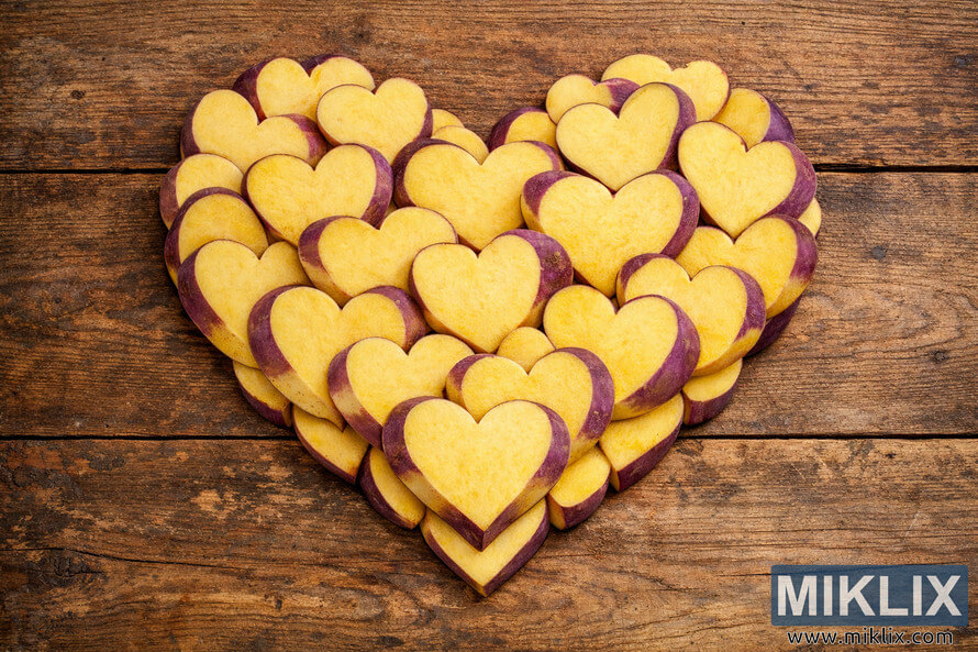 Heart-shaped arrangement of sliced rutabaga on rustic wooden surface symbolizing health and vitality.
