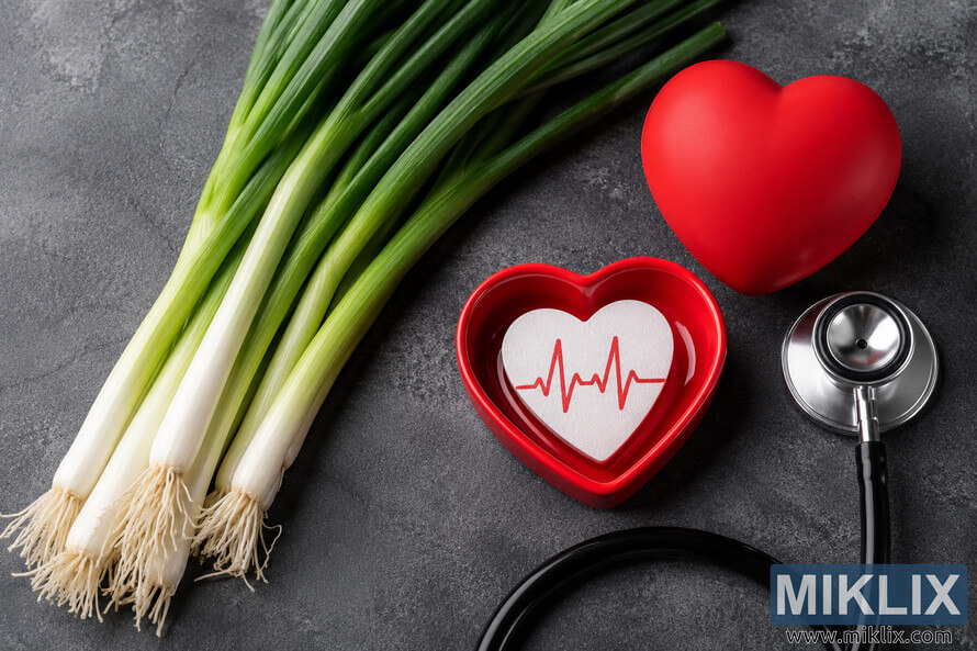 Fresh green scallions arranged on a dark textured surface beside red heart-shaped props and a stethoscope, symbolizing cardiovascular health, healthy eating, and wellness in a high-resolution landscape composition. Fresh green scallions arranged on a dark textured surface beside red heart-shaped props and a stethoscope, symbolizing cardiovascular health, healthy eating, and wellness in a high-resolution landscape composition.